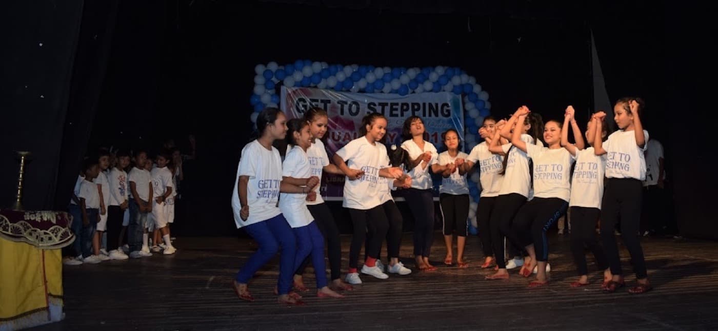 Junior students mid-routine on stage in Get To Stepping tees